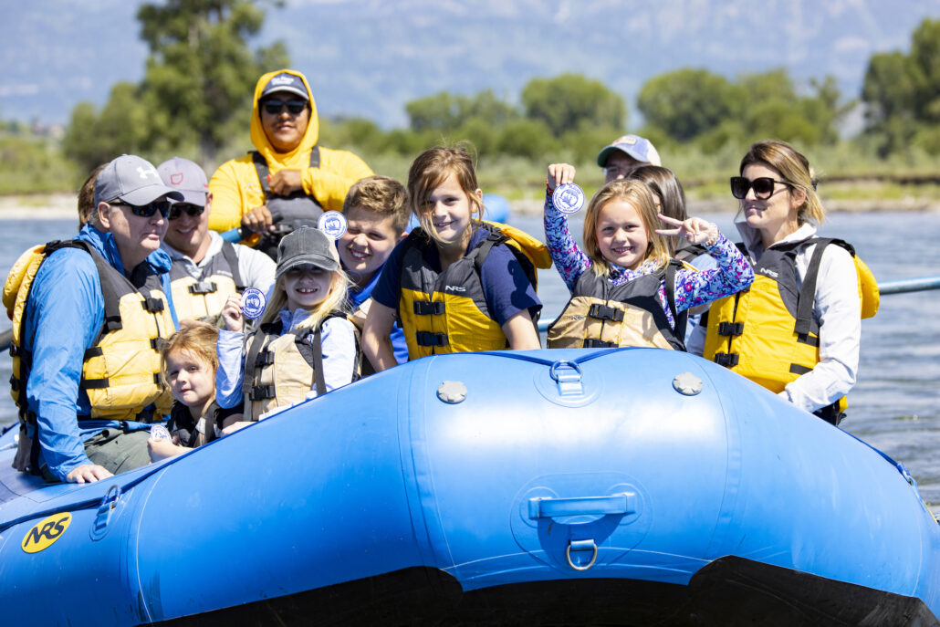 Happy children enjoying a scenic rafting experience in Jackson Hole.