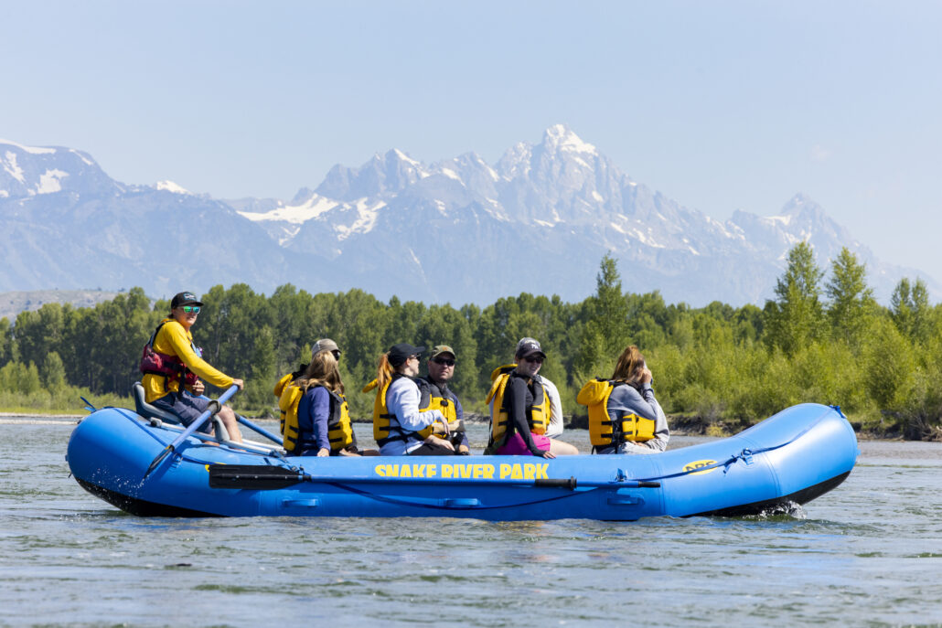 A guided scenic rafting trip floats down the Snake River with a view of the Tetons.